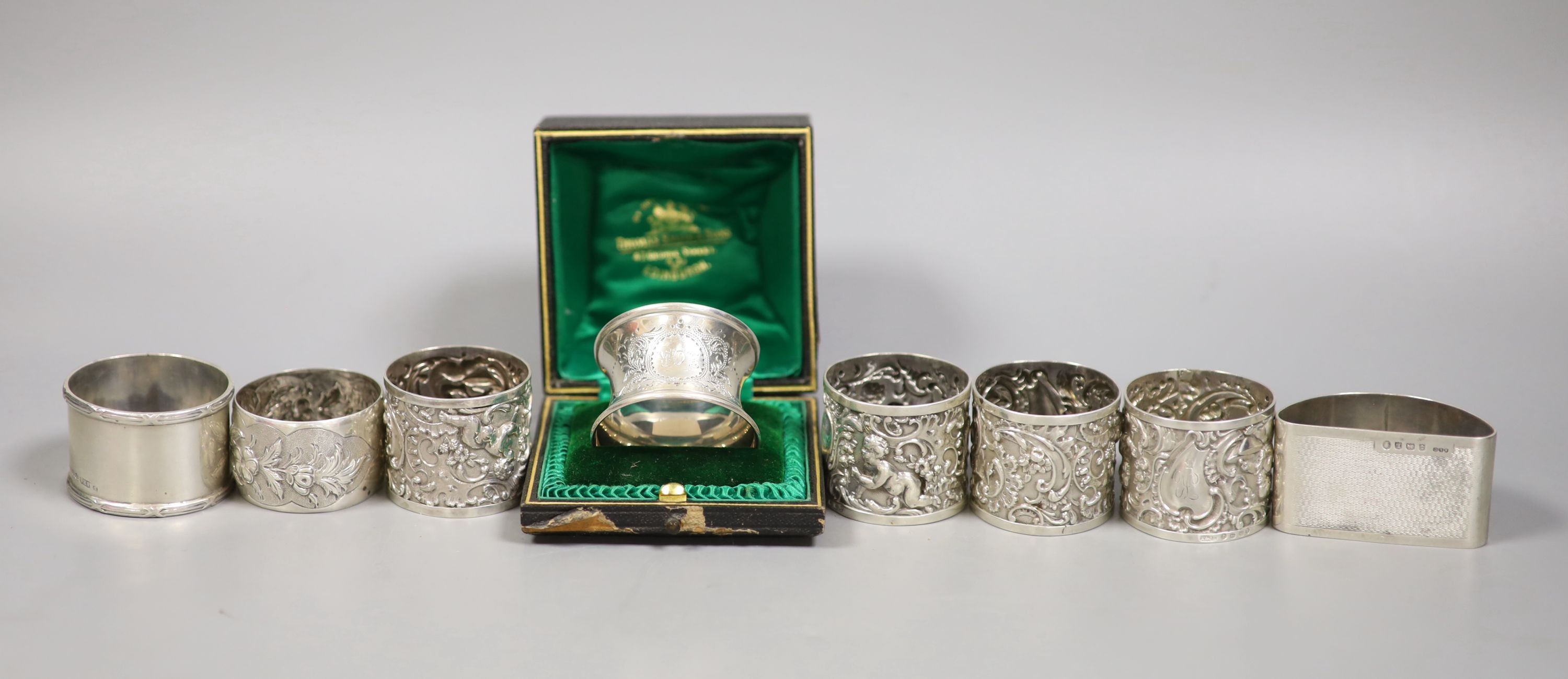 A set of four Victorian embossed silver napkin rings, A & J. Zimmerman, Birmingham, 1889 and four other silver napkin rings including one cased, 7.5oz.